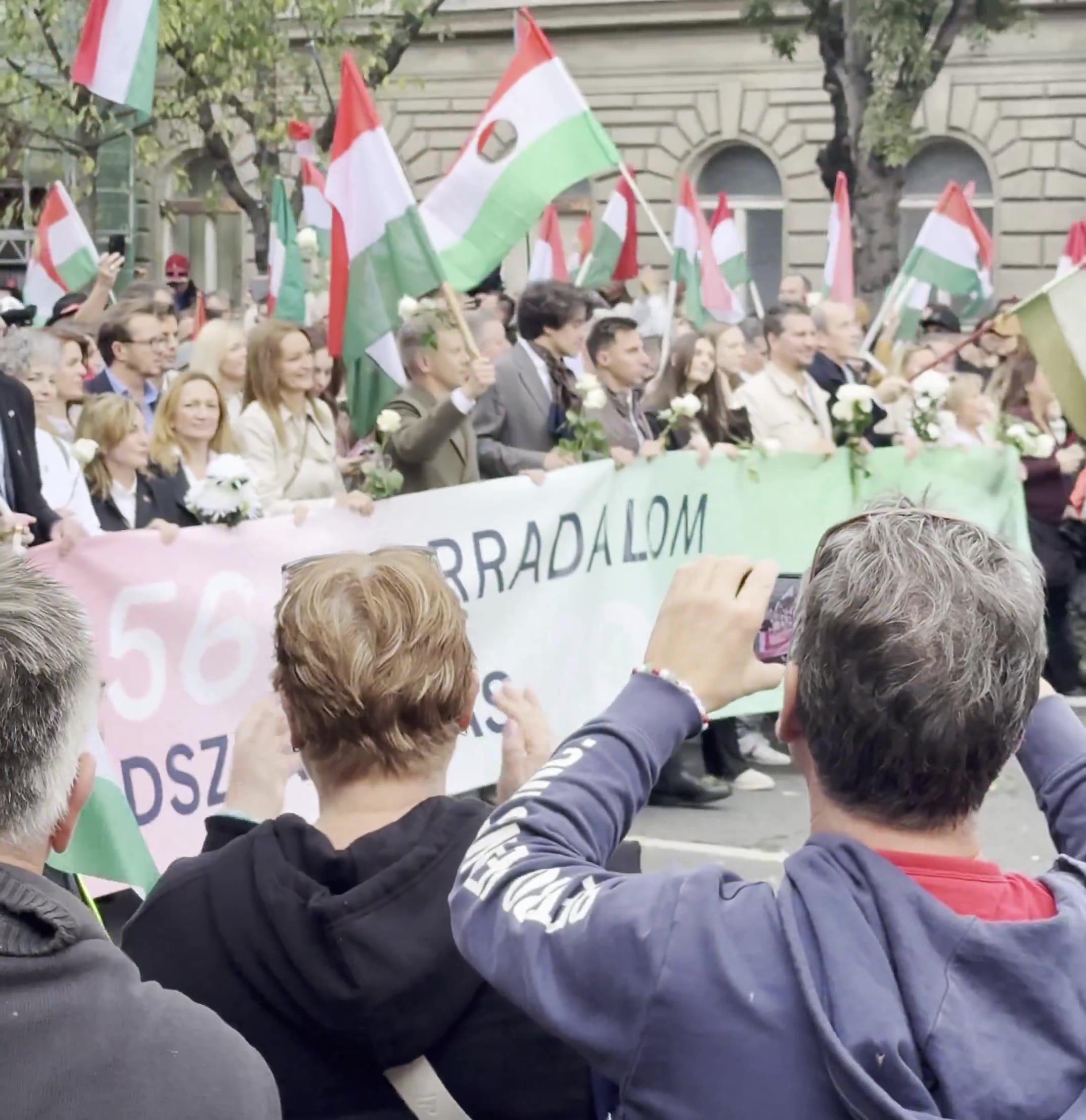 Budapest marks the anniversary of the 1956 anti-Soviet revolution with two major rallies. Orbán’s “peace march,” led by a banner reading “We won’t die for Ukraine,” has ended — now opposition leader Péter Magyar’s “national march” heads with supporters toward Heroes’ Square