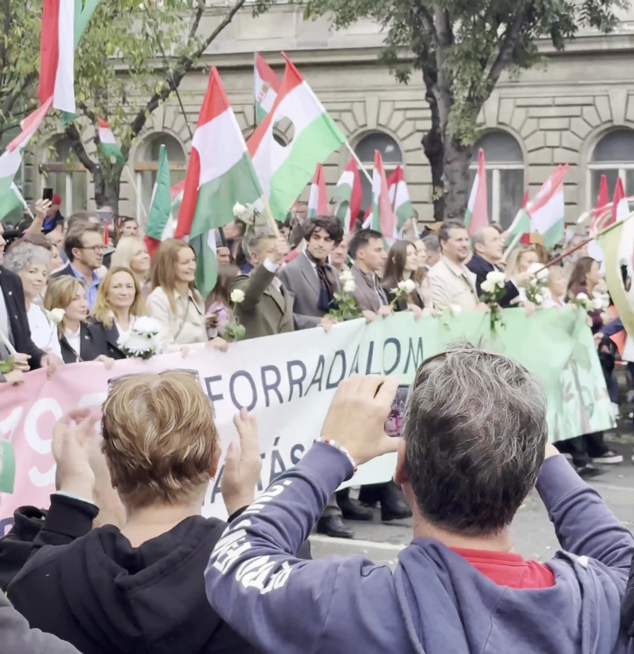 Budapest marks the anniversary of the 1956 anti-Soviet revolution with two major rallies. Orbán’s “peace march,” led by a banner reading “We won’t die for Ukraine,” has ended — now opposition leader Péter Magyar’s “national march” heads with supporters toward Heroes’ Square