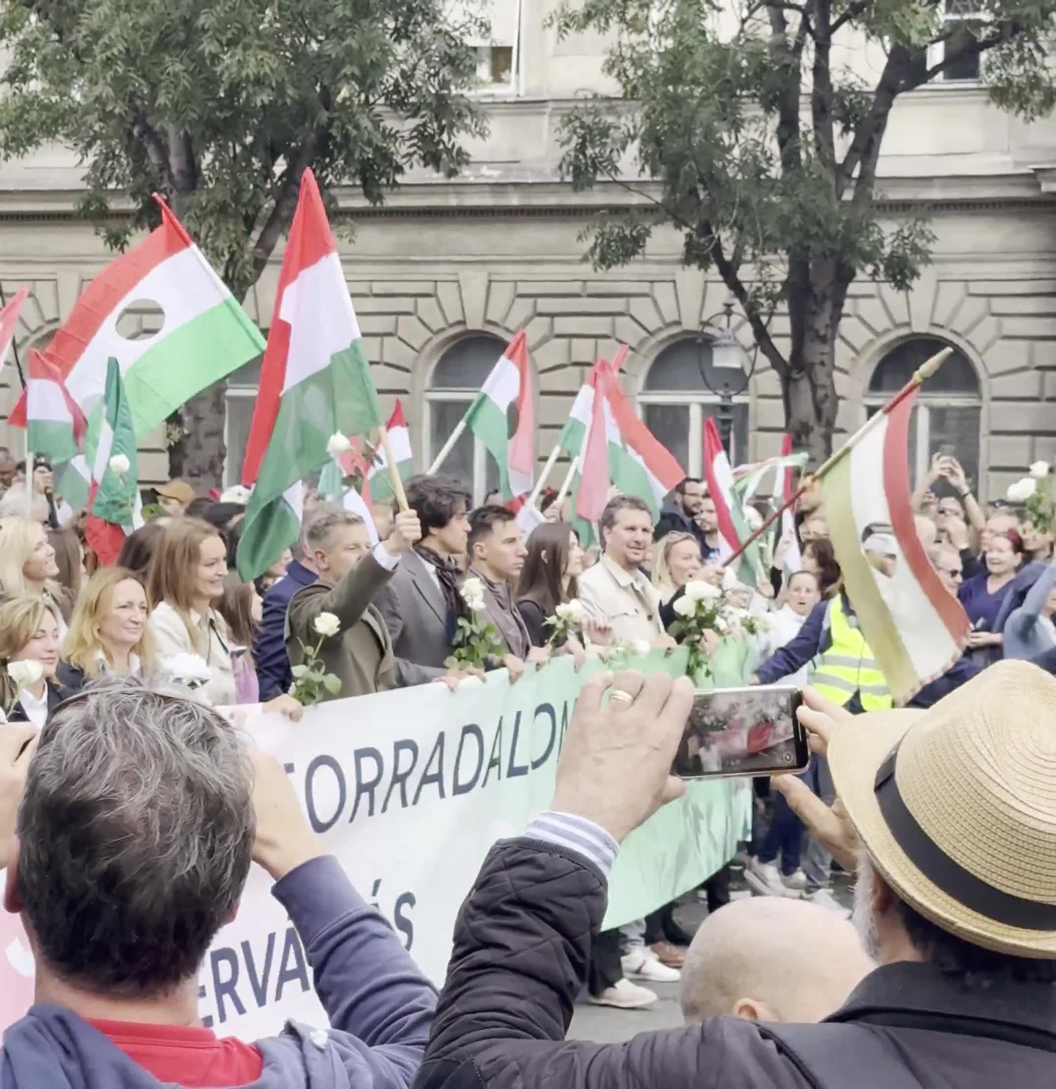 Budapest marks the anniversary of the 1956 anti-Soviet revolution with two major rallies. Orbán’s “peace march,” led by a banner reading “We won’t die for Ukraine,” has ended — now opposition leader Péter Magyar’s “national march” heads with supporters toward Heroes’ Square